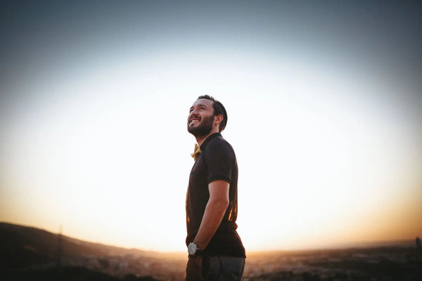 Mann lächelt zufrieden im Abendlicht, vermittelt Gelassenheit und Zuversicht.